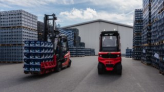 Unabhängig von den Lichtverhältnissen erkennt der Linde Reverse Assist Radar jedes Hindernis. Zwei Linde E-Stapler stehen auf dem Außengelände zwischen gestapelten Getränkekisten.